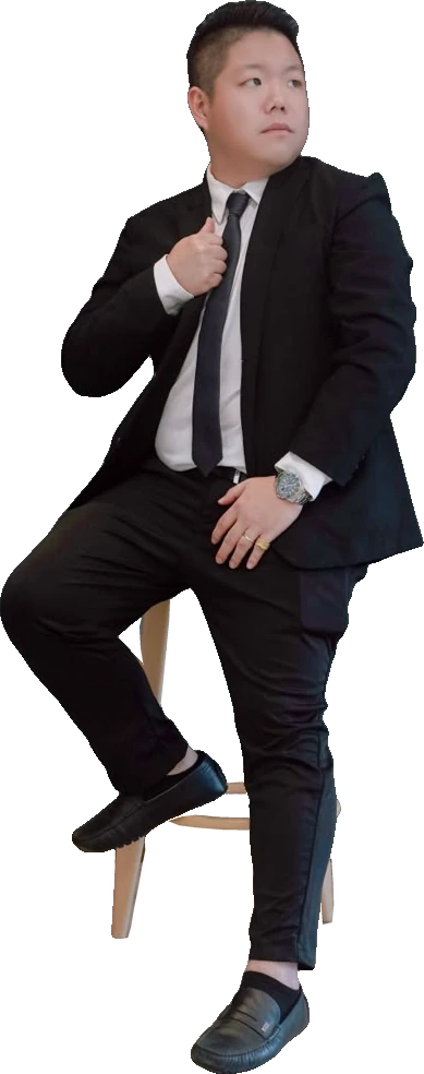 Jay Teh, founder of J Elites Group, in a dark suit and tie, seated on a stool